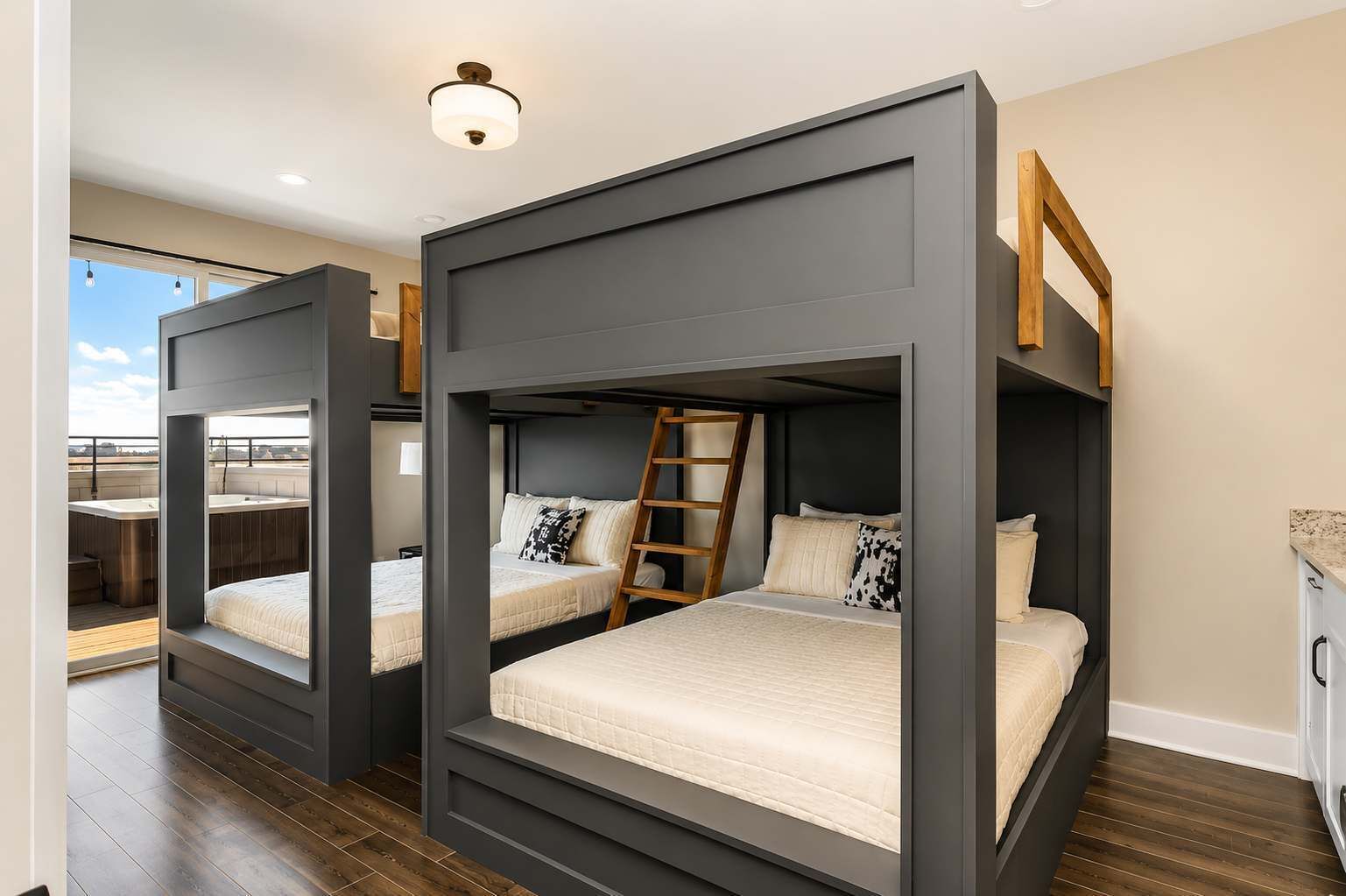 Een moderne slaapkamer met stapelbedden, een houten ladder en uitzicht op een terrasdak.