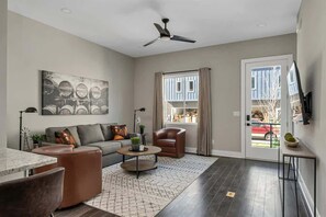 A modern living room with a sofa, coffee table, and a ceiling fan.