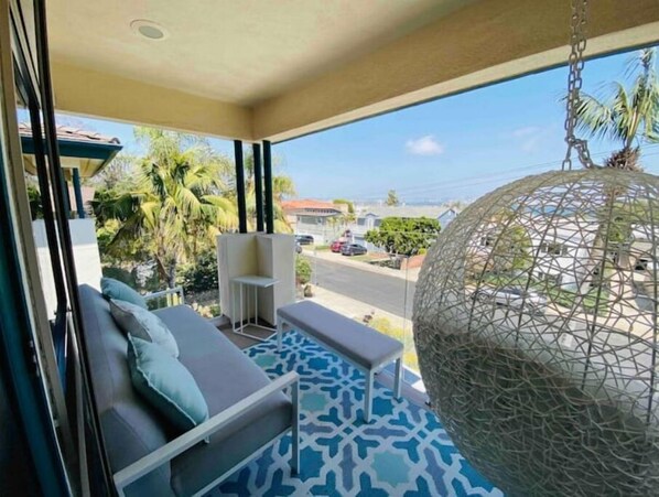 Relax on the balcony with a sofa and bench, taking in the view of the street and surrounding buildings.