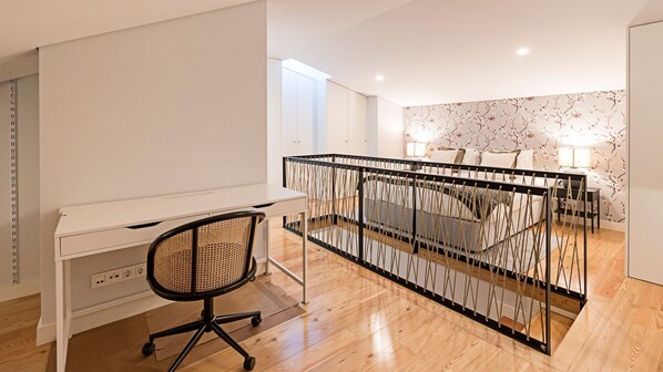 Un espace de bureau moderne avec un bureau blanc, un fauteuil de bureau noir et un panneau de séparation orné d’un motif en forme de corde.