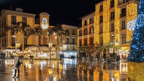 A plaza with buildings adorned with lights, a clock tower, and a Christmas tree. - Dreamers' Rooms Sorrento (Sorrento)