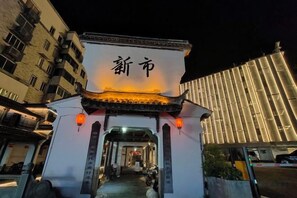 A traditional Chinese gate with illuminated characters, leading to a pathway. - Mimengyitan Holiday Inn (Deqing)