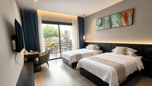 A hotel room with two beds, a desk, a chair, a TV, and a balcony with a view.