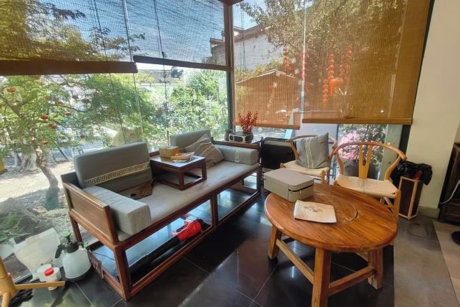 Una sala de estar moderna con sofá, mesa de centro y mesa de comedor de madera.