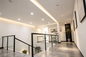 A modern interior with a staircase, recessed lighting, and framed artwork on the walls. - Mimengyitan Holiday Inn (Deqing)