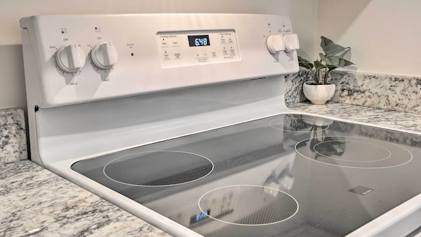 A modern kitchen with a built-in stovetop and oven, featuring control knobs and a digital display. - Ideally Located Studio w/ Off-Street Parking! (Gadsden)