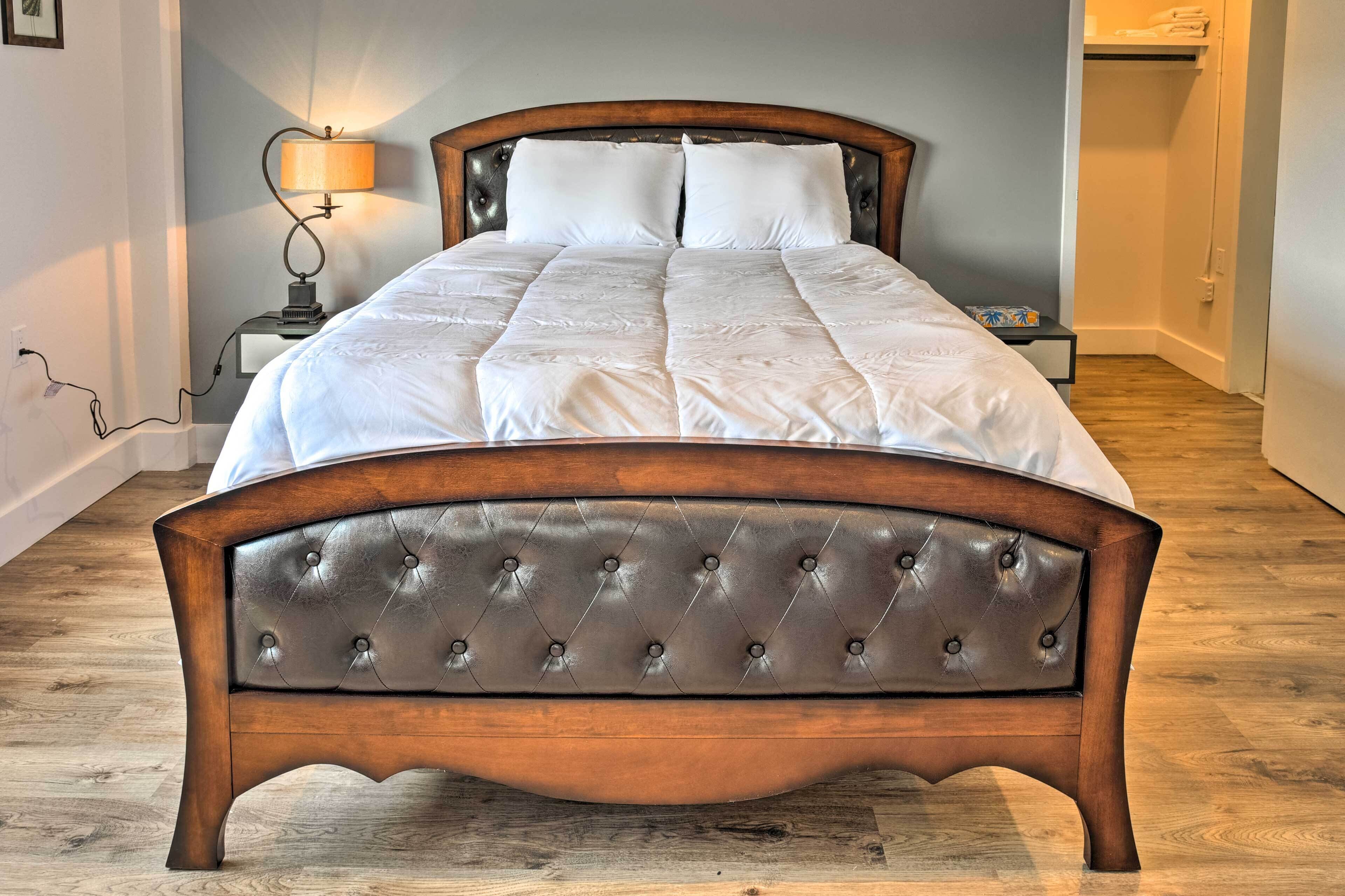 A neatly made bed with a wooden headboard and a bedside lamp.