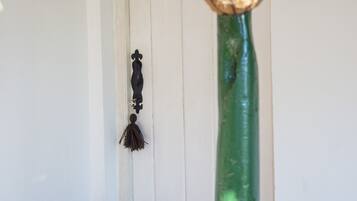 A green pole with a hanging planter and a black wall-mounted decoration.