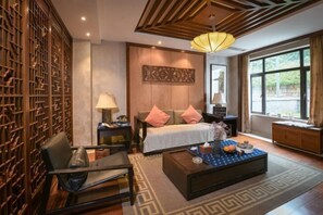A modern hotel room with a bed, bedside tables, a coffee table, and a large window. - Juanshui Hostel (Suzhou)