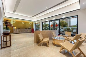 A hotel lobby with a reception desk, seating area, and large windows. - Jiangmen Jinli Hotel (Siqian Town Center Avenue Branch) (Jiangmen)