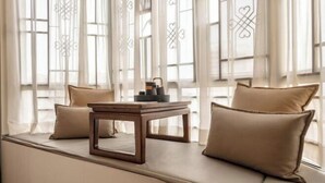 A window seat with cushions, a small table, and a decorative item. - Jiangmen Jinli Hotel (Siqian Town Center Avenue Branch) (Jiangmen)