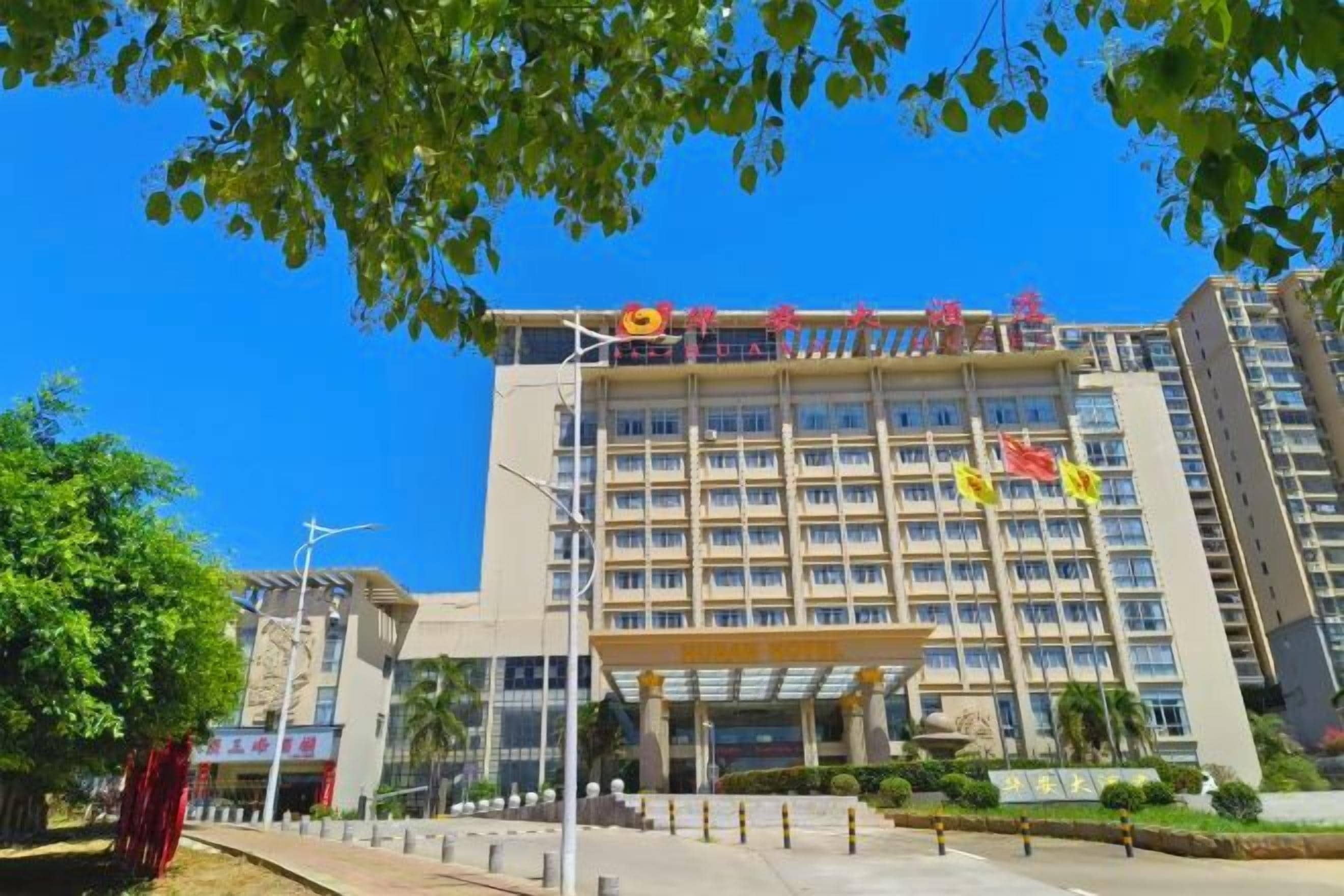 Ein mehrstöckiges Hotel mit einem markanten Eingang, einem überdachten Gang und blauem Himmel.