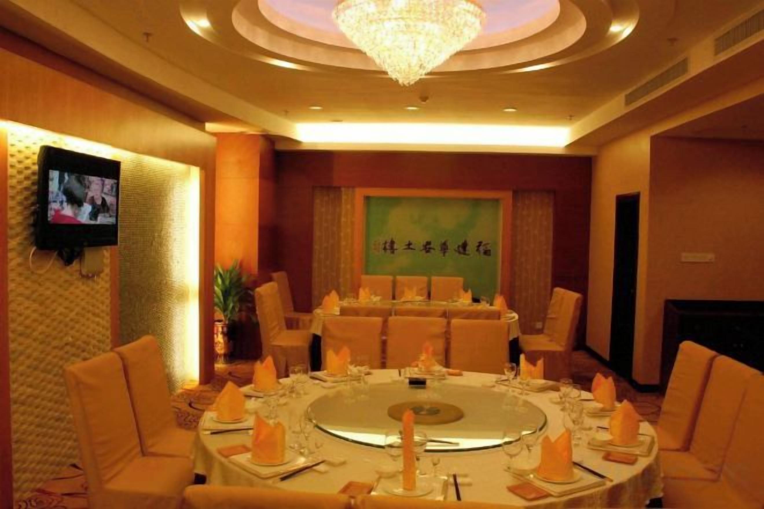 A conference room with a round table, chairs, and a chandelier.