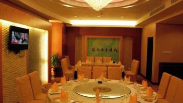 A conference room with a round table, chairs, and a chandelier.