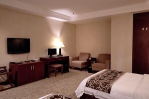 A hotel room with a bed, a desk, two chairs, a television, and a lamp. - Hua'an Hotel (Hua'an)