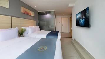 Una habitación de hotel con una cama grande, ducha y televisión en la pared.