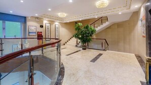 A spacious lobby with a marble floor, a staircase, and a large potted plant. - Shenzhen Lanyu Hotel (Dongmen Old Street) (Shenzhen)
