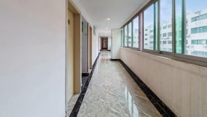 A corridor with a marble floor, large windows, and a view of buildings outside. - Shenzhen Lanyu Hotel (Dongmen Old Street) (Shenzhen)