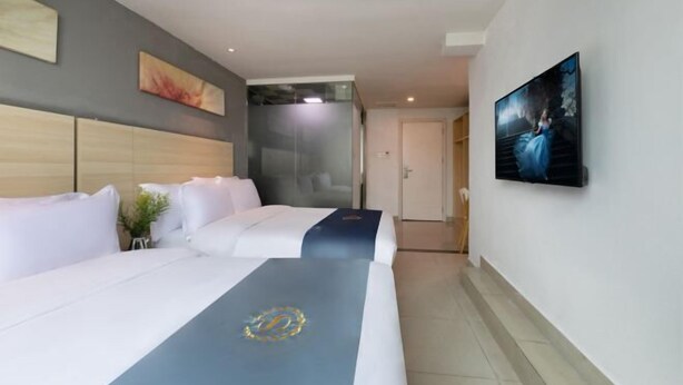 A hotel room with two beds, a large painting on the wall, and a glass partition. - Shenzhen Lanyu Hotel (Dongmen Old Street) (Shenzhen)