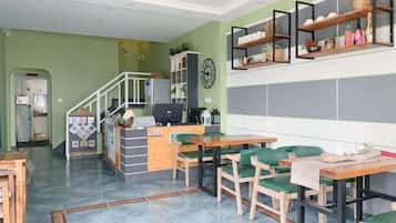 Un comedor con mostrador, sillas y una escalera que sube a una cocina.