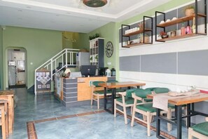 Ein Essbereich mit Theke, Stühlen und einer Treppe, die zu einer Küche führt.