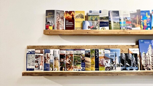 Dos repisas de madera con libros y folletos.