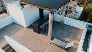 Une terrasse extérieure avec une table et des chaises, une pergola et une vue sur les environs.
