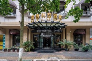 A hotel entrance with a glass facade, a canopy, and potted plants. - Boji Liya Hotel (Longli)
