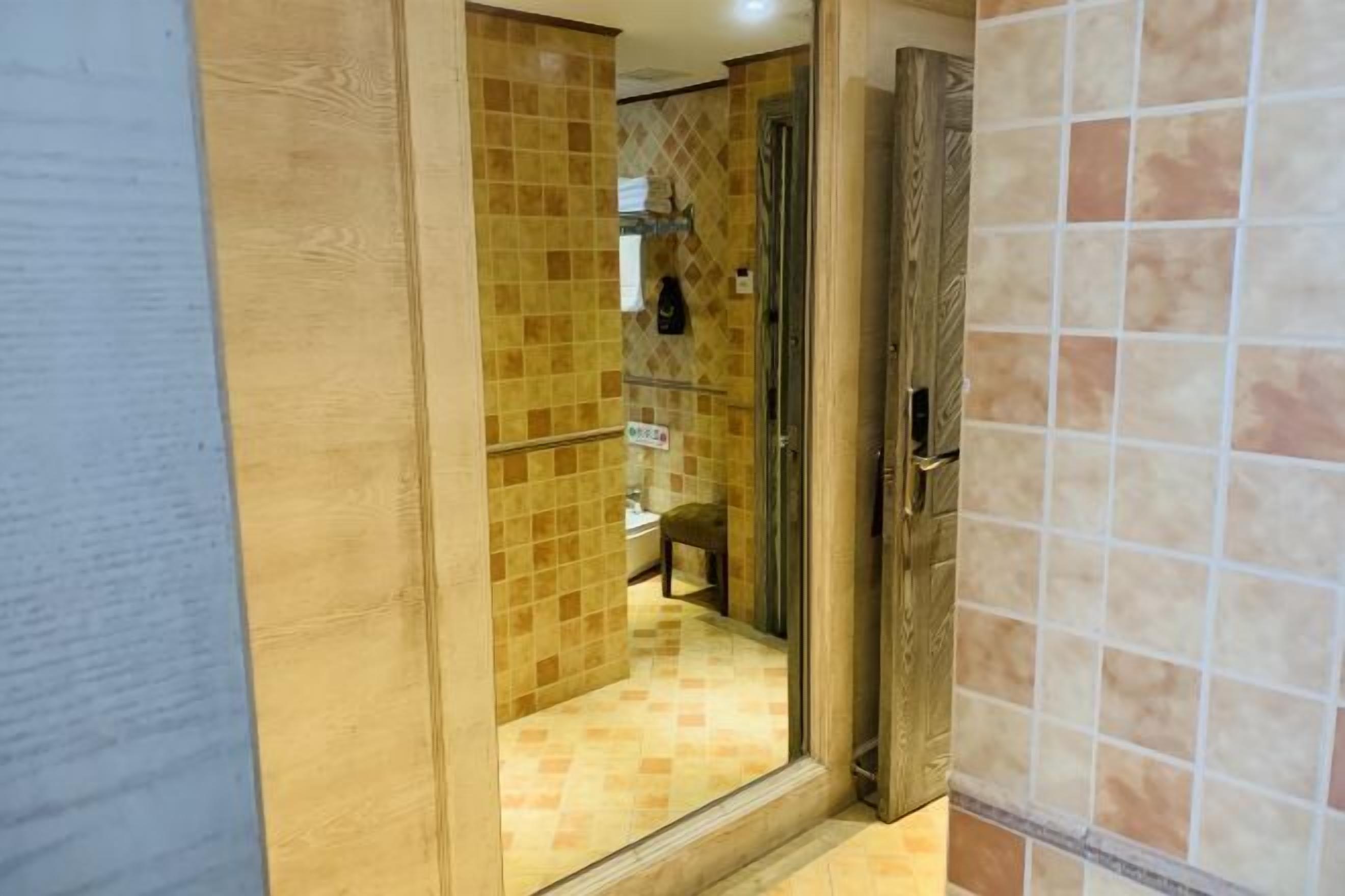 A bathroom with a glass shower enclosure, tiled walls, and a visible toilet.