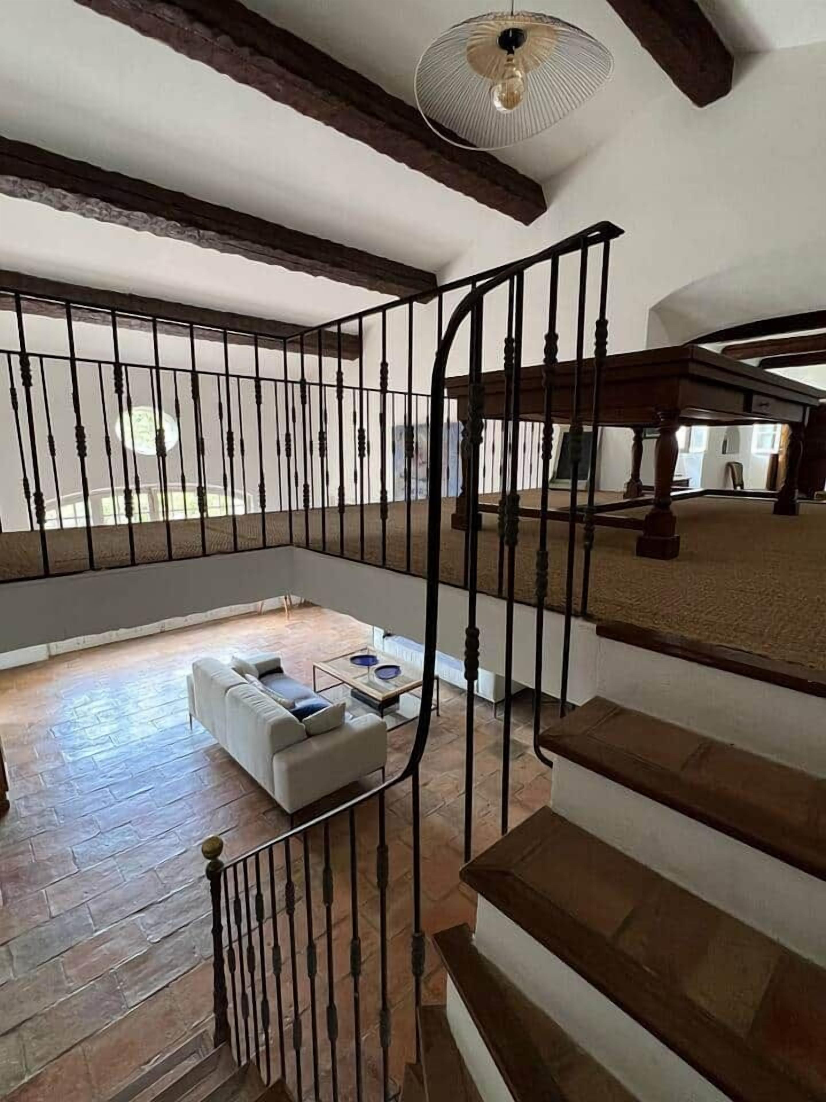 A spacious living area with a staircase, a white sofa, and a coffee table.