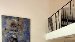 A living room with a sofa, a coffee table, a chair, a lamp, and a staircase.