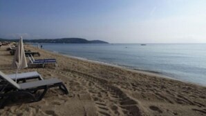 Una playa con tumbonas y una vista despejada del mar.