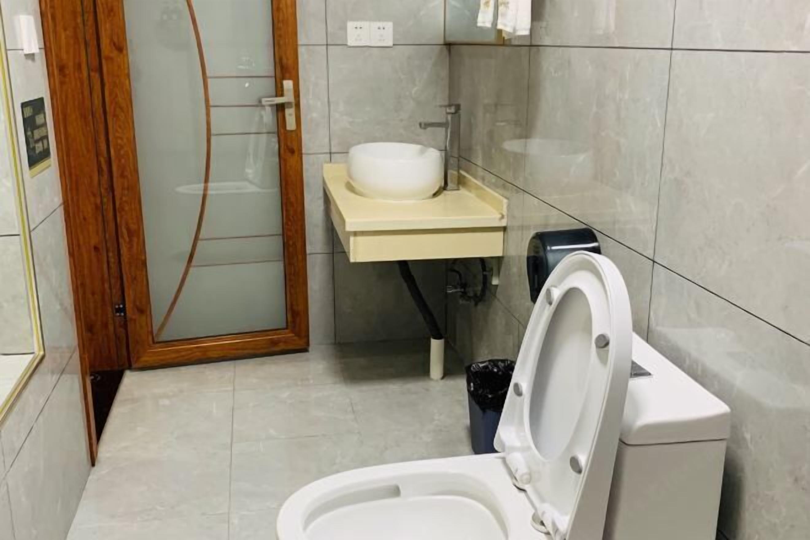 A bathroom with a toilet, a sink, and a glass shower enclosure.
