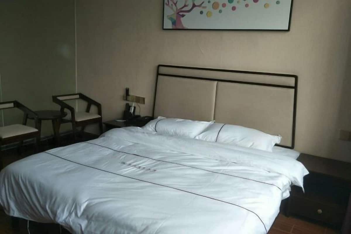 Una cama bien hecha con sábanas blancas en una habitación de hotel.