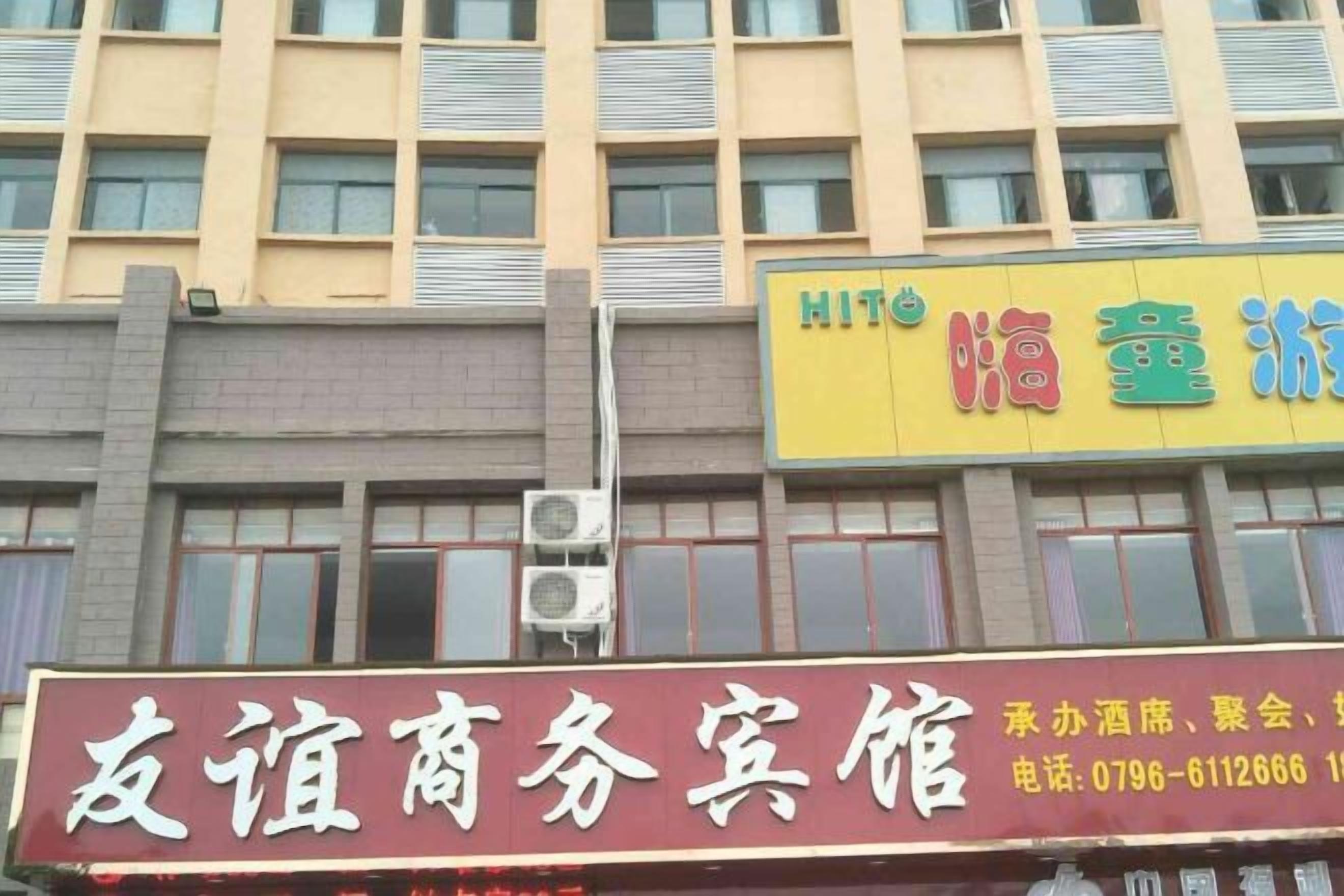 Un edificio con varios letreros, incluyendo uno para un centro de negocios y otro para un hotel.