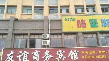 Un edificio con varios letreros, incluyendo uno para un centro de negocios y otro para un hotel.