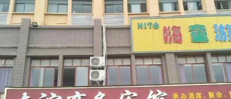 Un edificio con varios letreros, incluyendo uno para un centro de negocios y otro para un hotel.