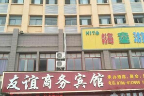Un edificio con varios letreros, incluyendo uno para un centro de negocios y otro para un hotel.