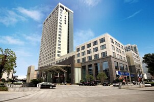 A modern hotel with a tall central building and a shorter wing.