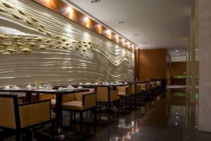 Un restaurant moderne dotĂ© dâune grande salle Ă manger, de lambris en bois et dâun sol rĂ©flĂ©chissant.