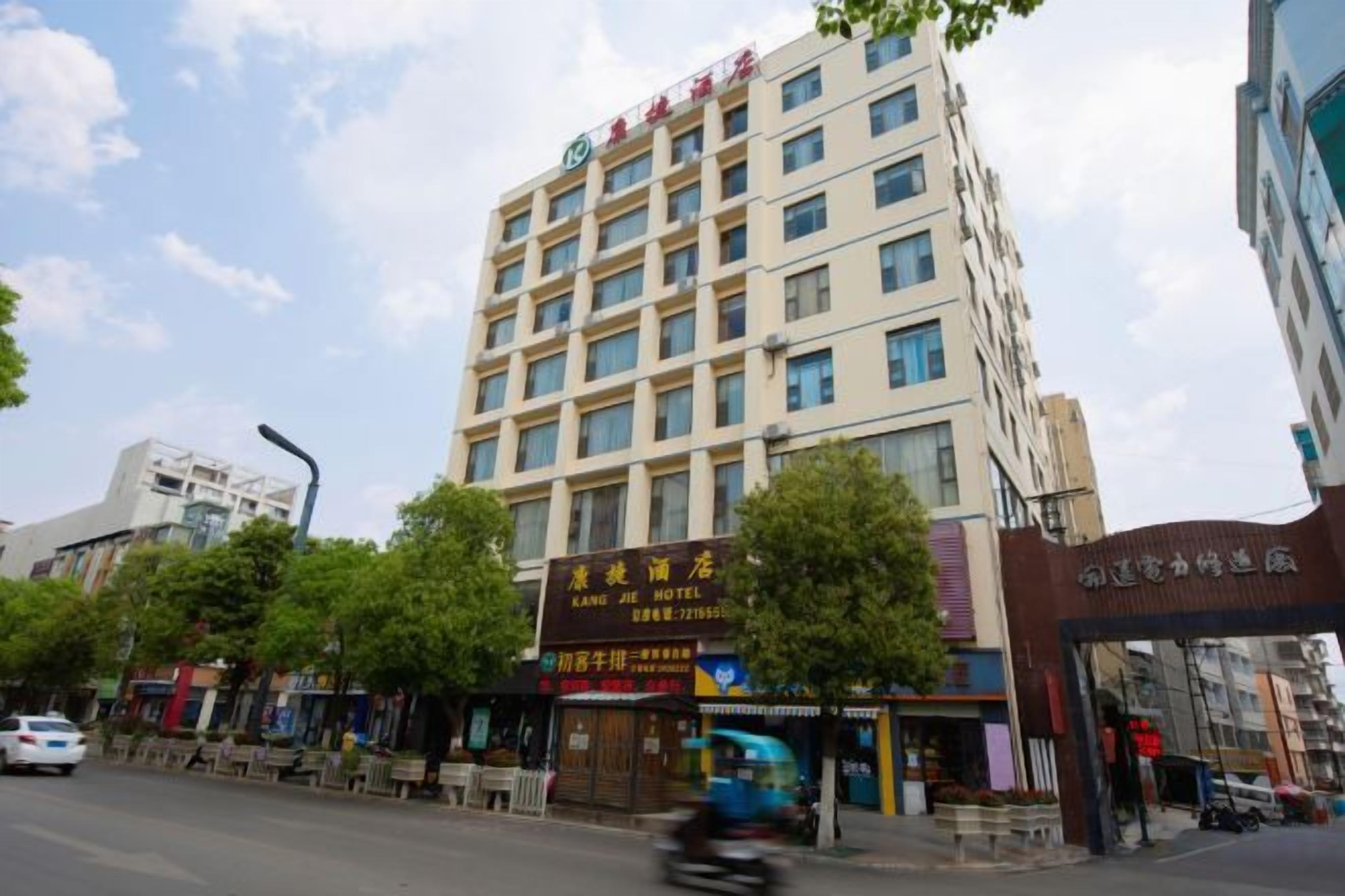 Un hotel de varios pisos con una entrada destacada y señalización.