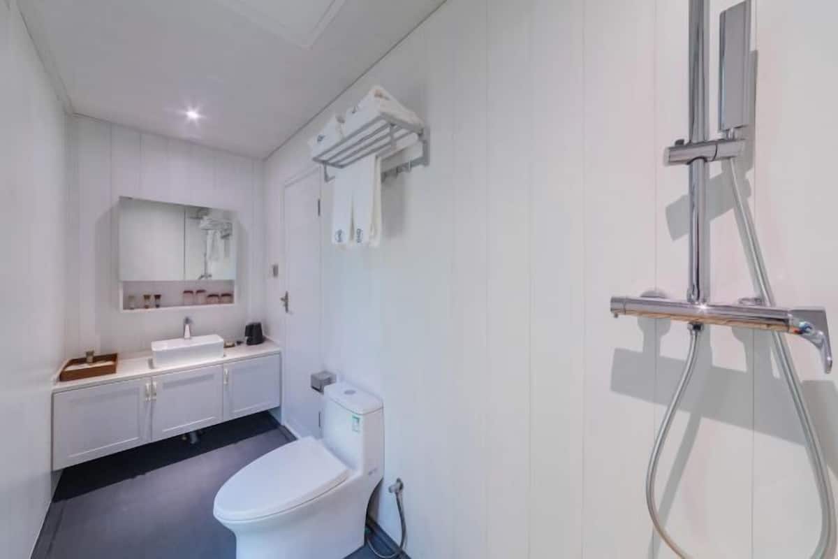 Een moderne badkamer met een wit toilet, een wastafel en een douche.