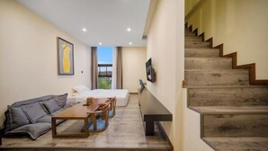 Un salon moderne avec un canapé, une table  à manger et un escalier.