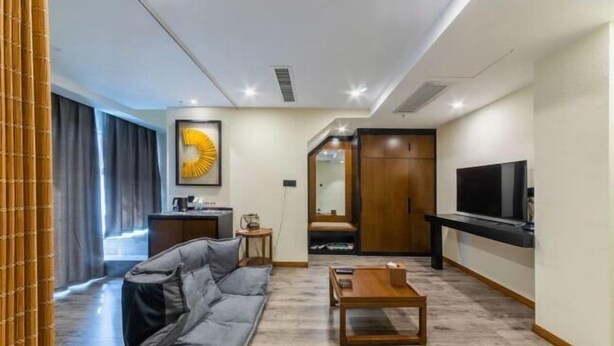 Un salon moderne comprenant un canapé, une table basse, un téléviseur et un meuble en bois.