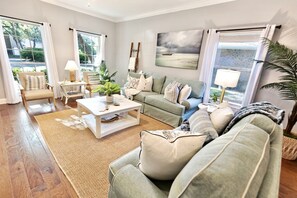 A living room with a sofa, coffee table, and a painting on the wall.