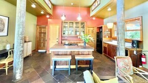 A spacious kitchen with a central island, wooden cabinets, and pendant lighting. - Unique Cypress cottage, close to Charlottesville with mountain views. (Charlottesville)