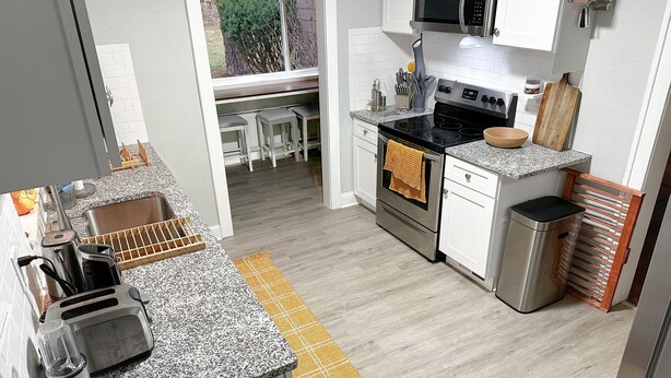 Una cucina moderna con piani di lavoro in granito, elettrodomestici in acciaio inossidabile e vista sul giardino.