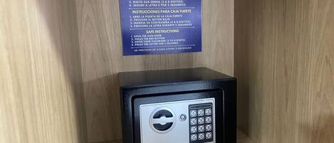 A safe with instructions in Portuguese, placed in a wooden cabinet.
