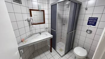Une salle de bain avec un lavabo, un miroir et des toilettes.