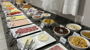 A buffet with various food items and utensils. - Ilha Forte Praia Hotel (Florianópolis)
